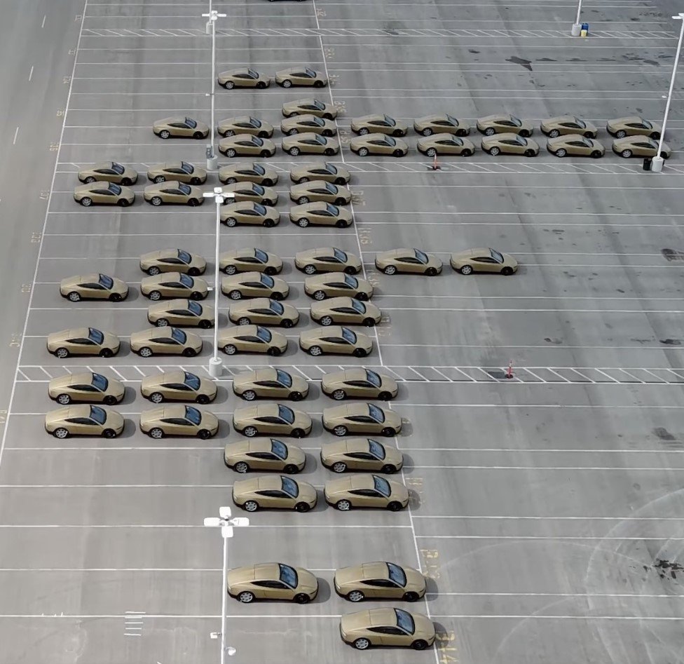 Aerial drone shot of approximately 100 Tesla Cybercab vehicles staged together, captured by @JoeTegtmeyer on X